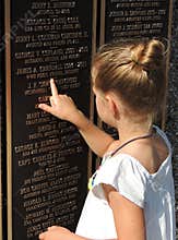 Little girl points to a loved ones name on EAA Memorial Wall in Oshkosh, WI