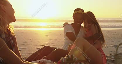 Young adult friends relaxing on the beach at sunset 4k