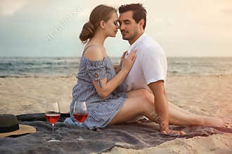 Happy young couple having picnic at sea