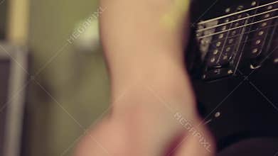 Plugging a jack into electric guitar and tuning. Musician is going to play. Musical instruments