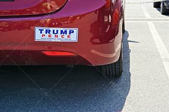 Contrasting bumper sticker Trump Pence on red car