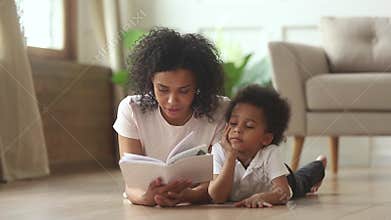 African son lying on floor with mother reading fairytale story