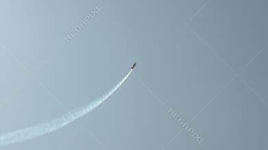 In blue sky flying aircraft Changes trajectory high up Leaves grey trail