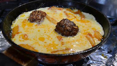 Omelet with cheese in a pan on a gas stove