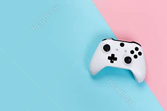 White joystick gamepad, game console on pink and blue background. Computer gaming technology play competition videogame control