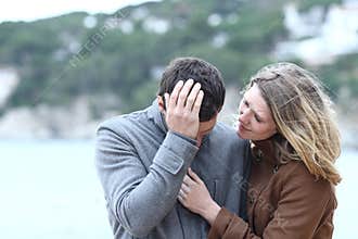 Woman comforting a sad man in winter