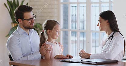 Woman paediatrician and kid girl patient talk at paediatric checkup