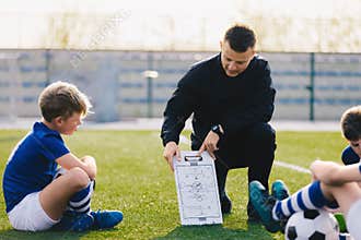 Young Soccer Trainer Coach Explaining Tactic on Team Sports Tactics Board