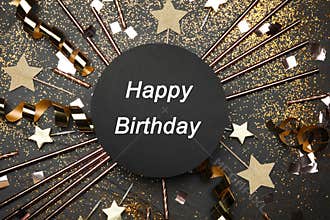 Flat lay composition with decor and text Happy Birthday on black background