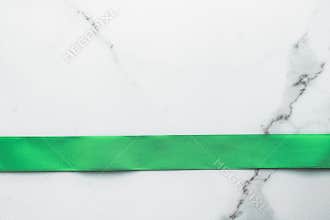 Green silk ribbon and bow on marble background, St Patricks day present or Christmas glamour gift decor for luxury digital brand,
