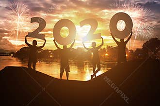 Silhouette young people hold on New year 2020 logo with sky background