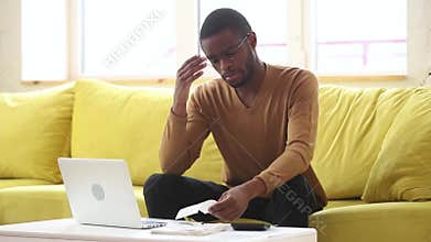 Stressed African man calculate bills worried about bankruptcy financial problem