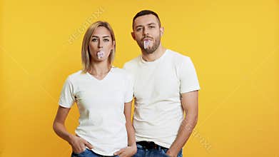 Young couple blowing bubbles with chewing gum