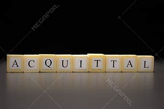 The word ACQUITTAL written on wooden cubes, isolated on a black background