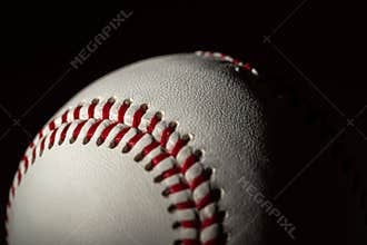 A white leather baseball on a black background