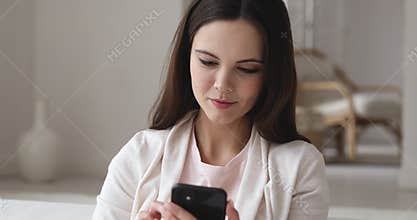 Happy girl looking at smartphone trying new makeup using app