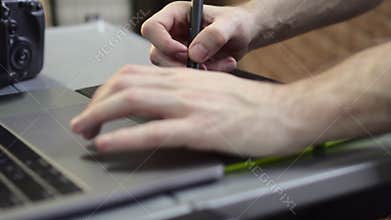 Hands of a male photographer, designer use a graphics tablet.