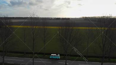 Urk Netherlands April 2019, couple having a picnic on the beach with an old classic camper van, Classic Minty Green and