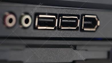USB cable is inserted into socket. Black panel with colored connectors for microphone and headphones, and also Universal Serial Bu