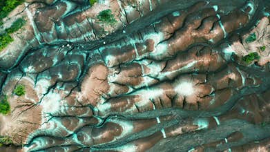 Aerial: top view of dry land, brown and white soil in Cheltenham Badlands, Ontario Canada. Flying over smalls rivers, dry soil, w