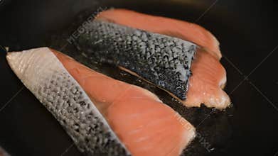 Two pieces of salmons steak grilled in the pan with little oil