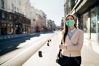 Concerned woman walking to work in public space during pandemic.Effect of the COVID-19.Protective measure,mask wearing.Respecting