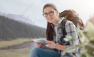 Girl hiking and connecting with a tablet