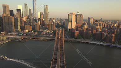 AERIAL: Flight over Brooklyn Bridge with view over Manhattan New York City Skyline at Sunset in beautiful