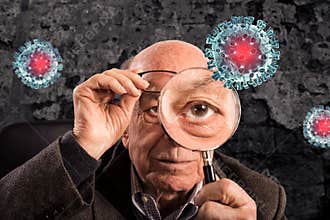 Elderly man looks with magnifier a covid19 coronavirus