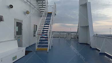 Walking at sunset on white ferry deck moored at the port waiting for departure to holidays, beautiful sky and relaxing atmosphere