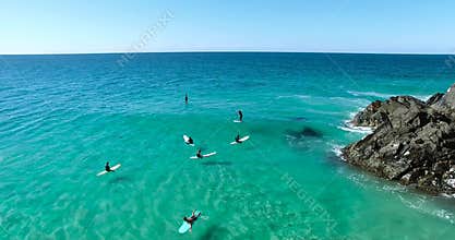 Extreme kind of sport. Austalian ocean view from above. Surfers on longboards ride on the waves. Summer time fun. 