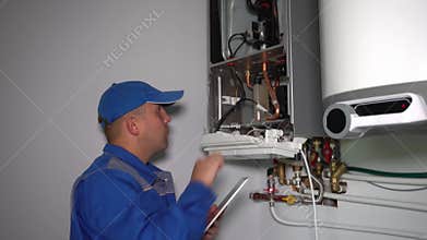 Man engineer with tablet computer repairing gas heater system