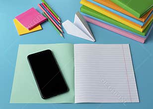 Distance Learning Concept. Pile of books, notebook, pencil, mobile phone. Student desk on online learning.