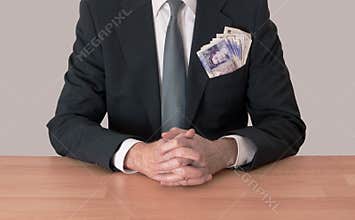 Man at desk with money, UK pounds