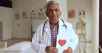 Indian mature cardiologist show postcard with heart symbol