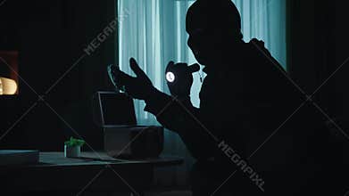 A thief in a black balaclava commits a burglary, stealing cash, valuables close up. The alarm goes off, the robber runs