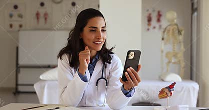 Latina female cardiologist calling to patient using video conference