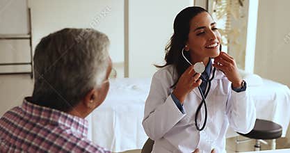 Female cardiologist check heart rate of older male patient