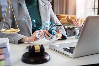 Judge in a courtroom using laptop and tablet with AML anti money laundering icon on virtual screen
