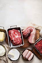Saturated fats on tables. Raw meat, sausages, cheese, butter. Bad food concept
