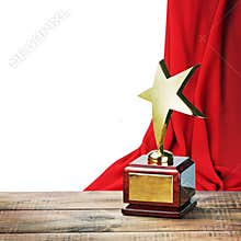 Star award wooden table and on the background of red curtain