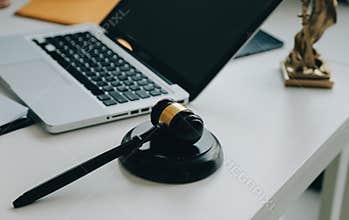 Judge gavel with Justice lawyers having team meeting at law firm in background. Concepts of law