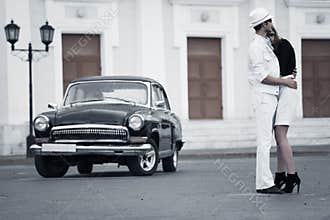 Young fashion couple in love at the retro car