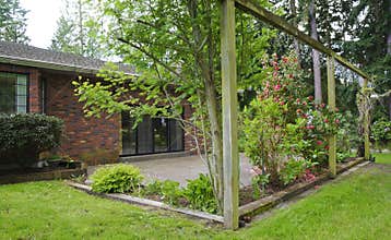 Brick house exterior backyard with patio and roses.