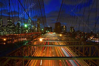 Brooklyn Bridge steel structure with fast moving traffic road at twilight with Manhattan in the background, New York, USA America