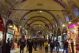 Busy rush hour crowd of visitor tourists, local customers & passerby with shops on both sides at Grand Bazaar, Istanbul, Turkey