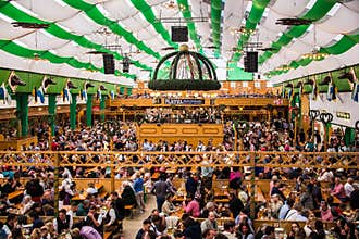 A crowd of drunken people are gathered together to celebrate Oktoberfest.