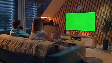 Woman switching channels on TV near man