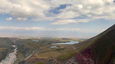 Stunning view from a height of the mountains, lakes, rivers and hills of Kyrgyzstan. The amazing nature of the Pamirs.