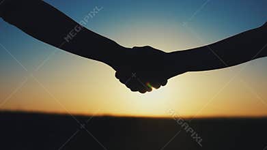 handshake farmers silhouette. agriculture business concept. close-up farmers hands silhouette shaking hands sun